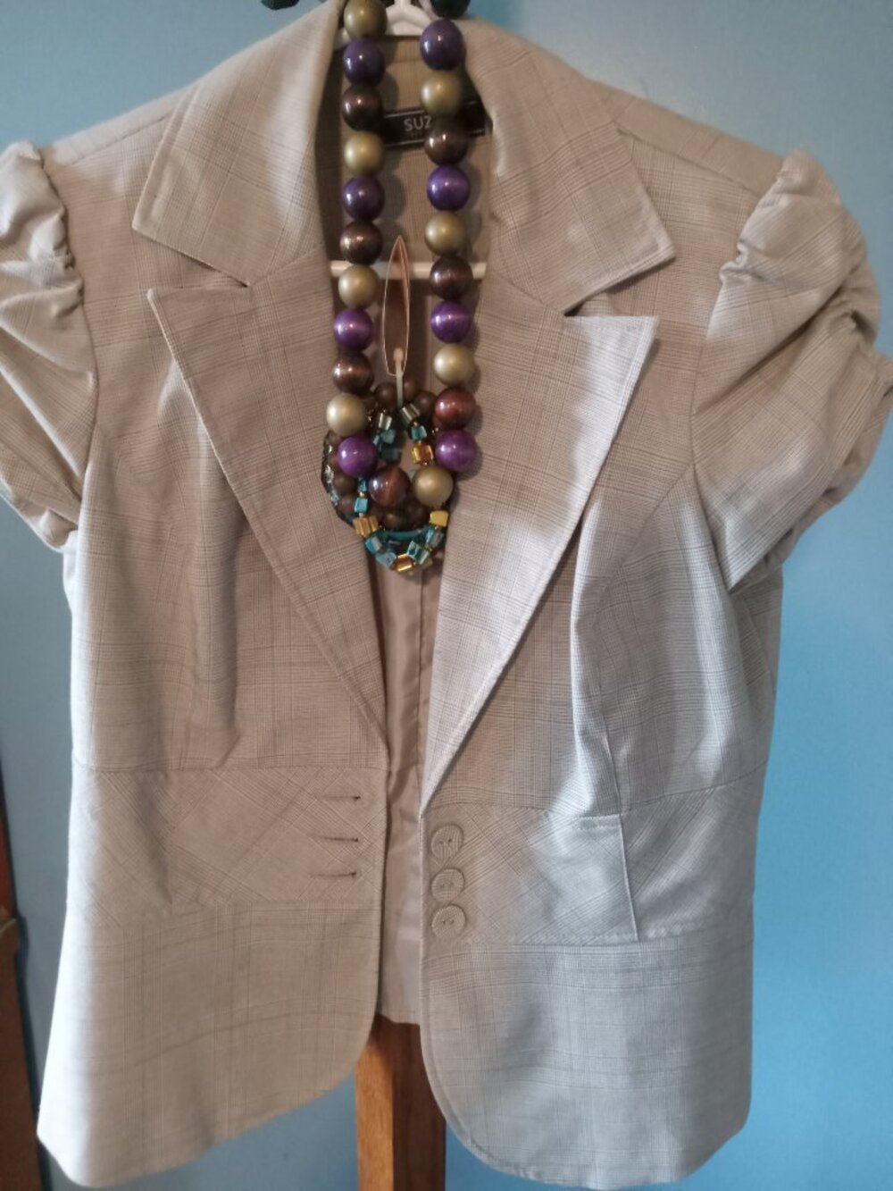 Ladies short sleeve fitted blazer with wooden necklace and set of bracelets